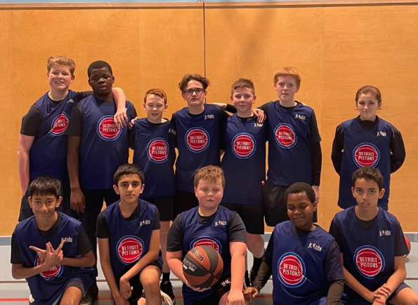 A team in basketball kits smiling for a photo